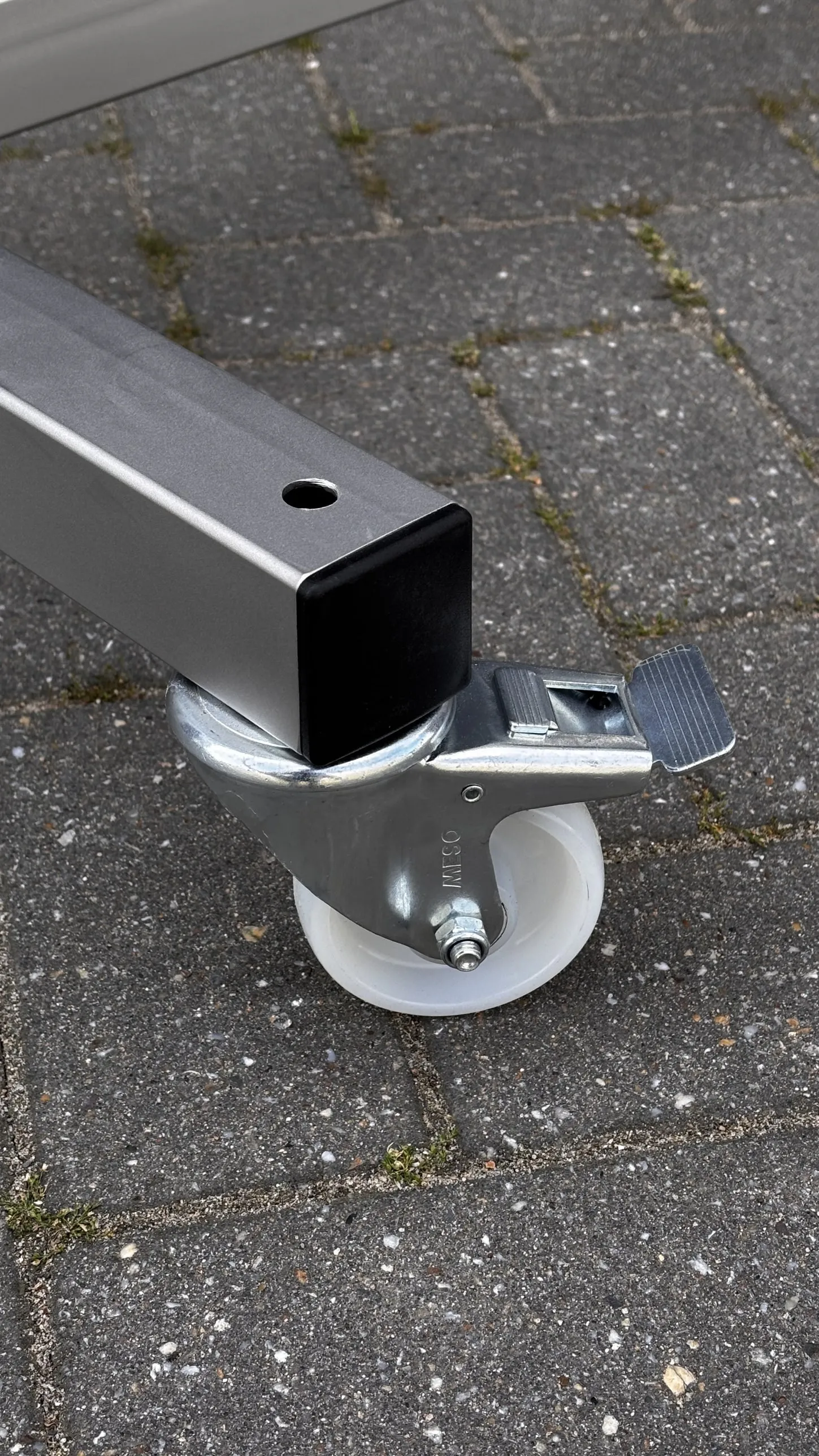 Zwenkwiel met rem onder het frame van de materiaalkar